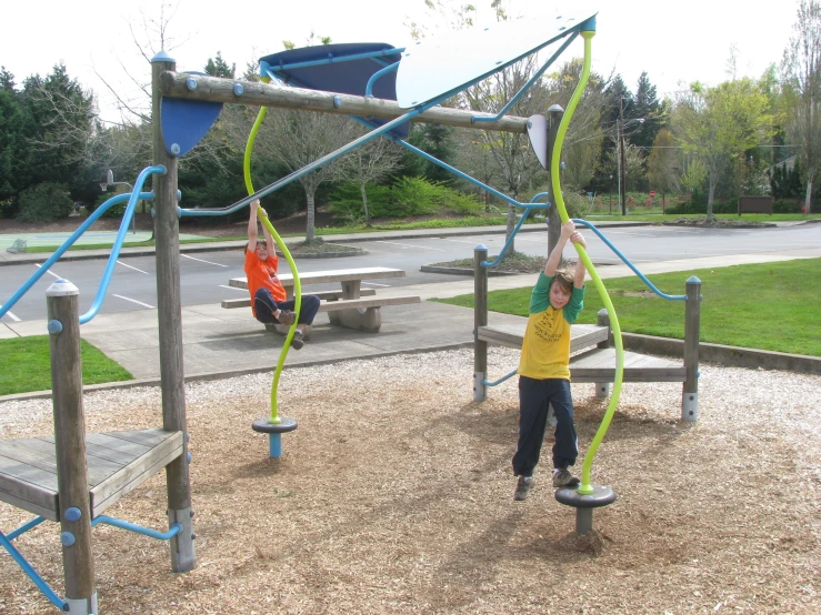 a  stands on top of a wooden swing set in a playground