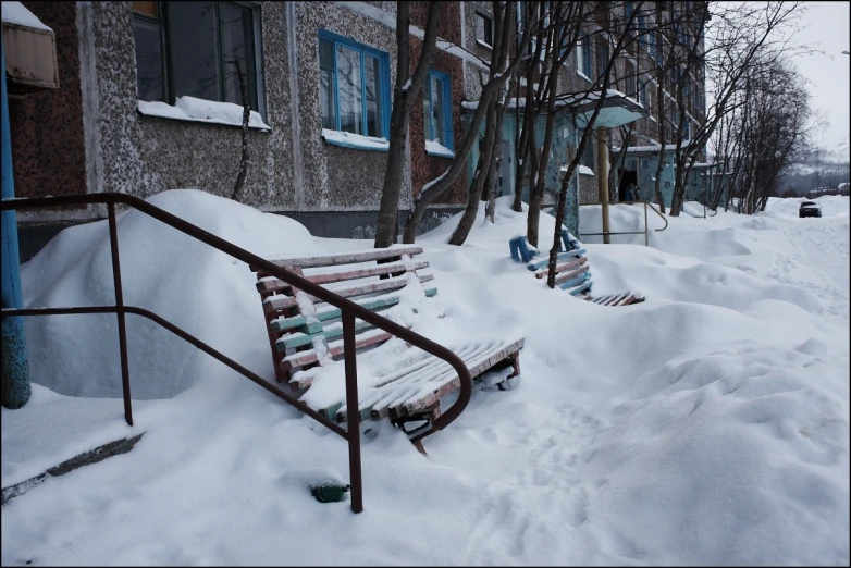 a sidewalk and a few buildings covered in snow