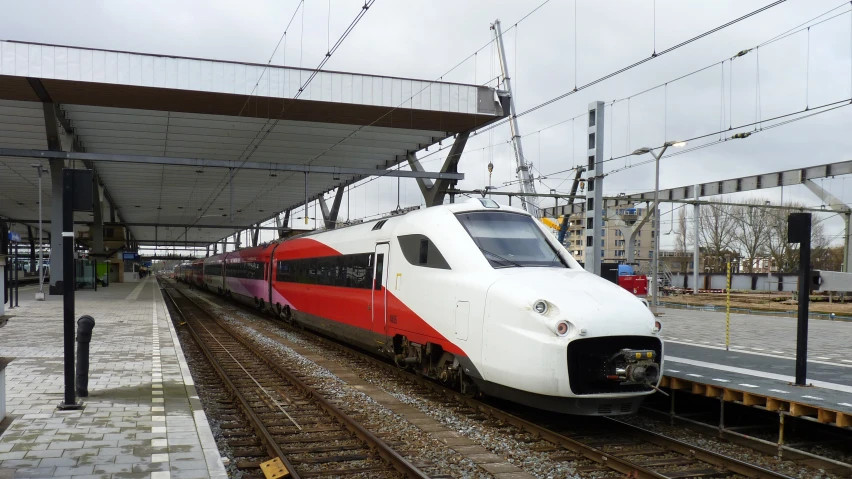 a commuter train waits for passengers at a platform