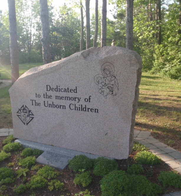 a large stone statue sitting next to trees