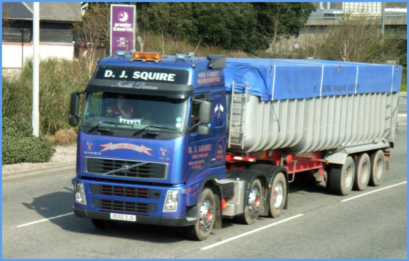 a truck drives down a street with a banner on the side