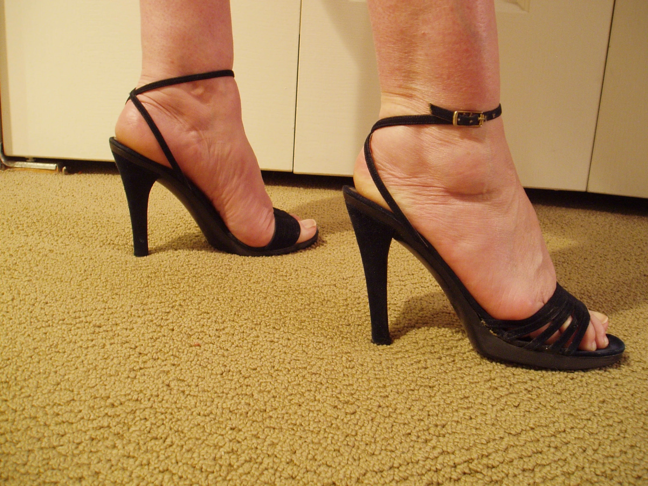 a person standing in front of a counter with high heel shoes on