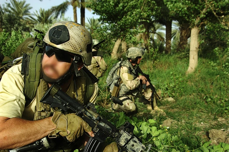 a man kneeling down while holding a gun