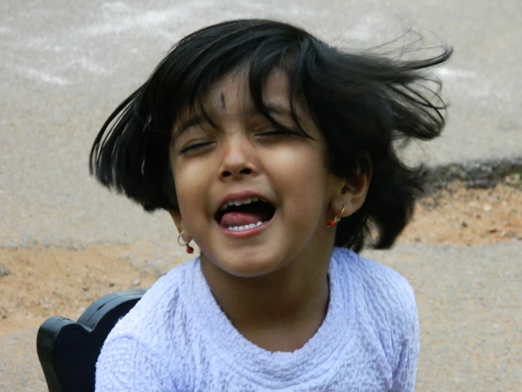 an up - close po of a little girl smiling and showing her teeth