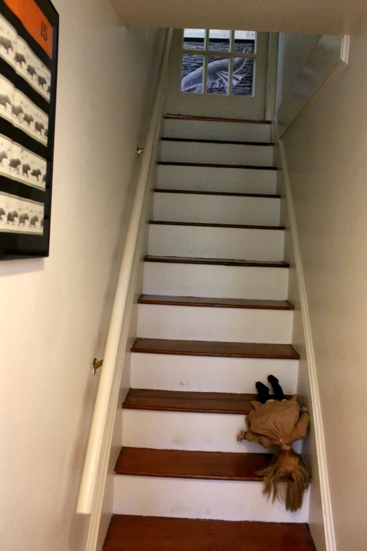 shoes are on the floor in the corner of the staircase