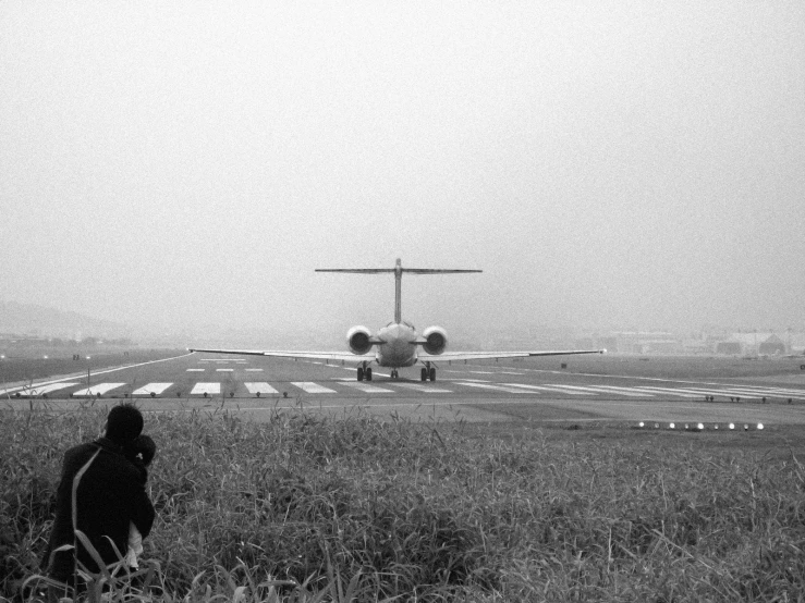 there is a black and white po of an airplane coming in for landing