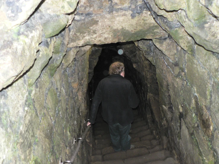 a man is walking up stairs in a tunnel