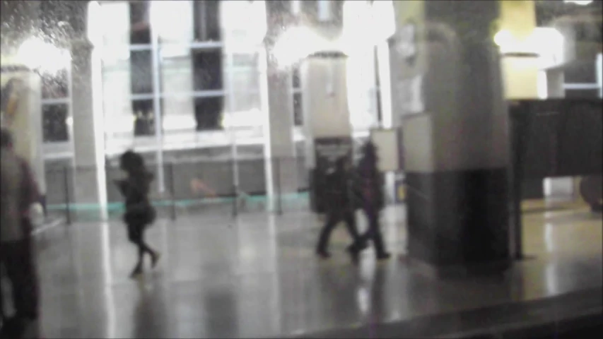 blurry pograph of people on sidewalk with bus passing