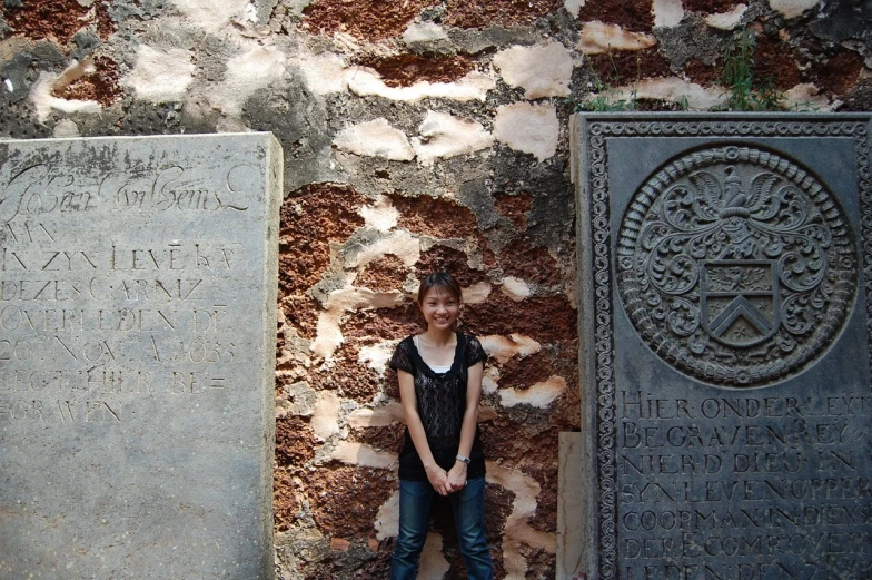 a person that is standing by some very nice tombstones