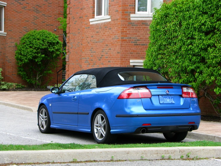 a small blue convertible cab parked on the side of the road