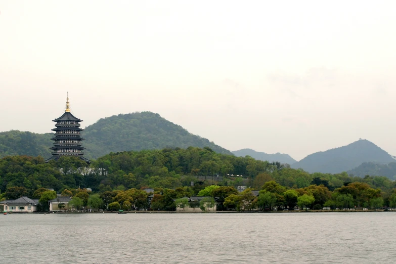 mountains and houses are behind the water near a lake