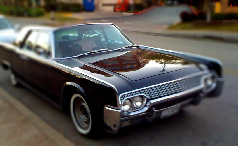 old time black cadillac parked on the side of the road