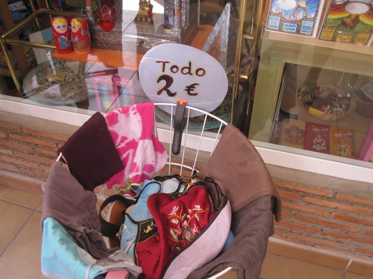 clothes are hanging up in the basket outside of a store