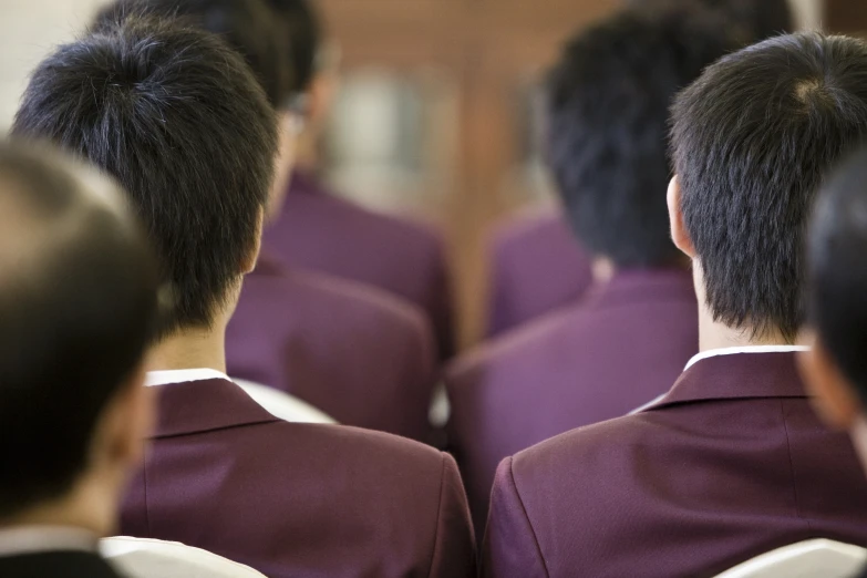 several men wearing purple uniforms looking at soing