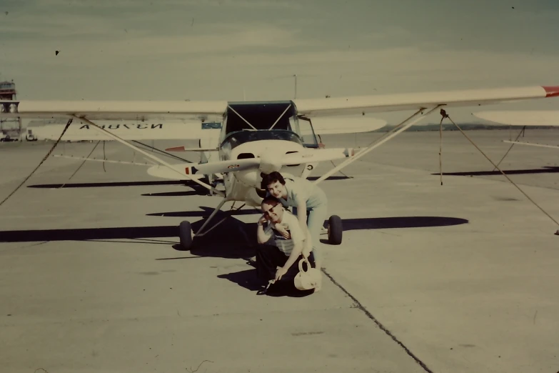 a man is putting on his shoes next to a small airplane