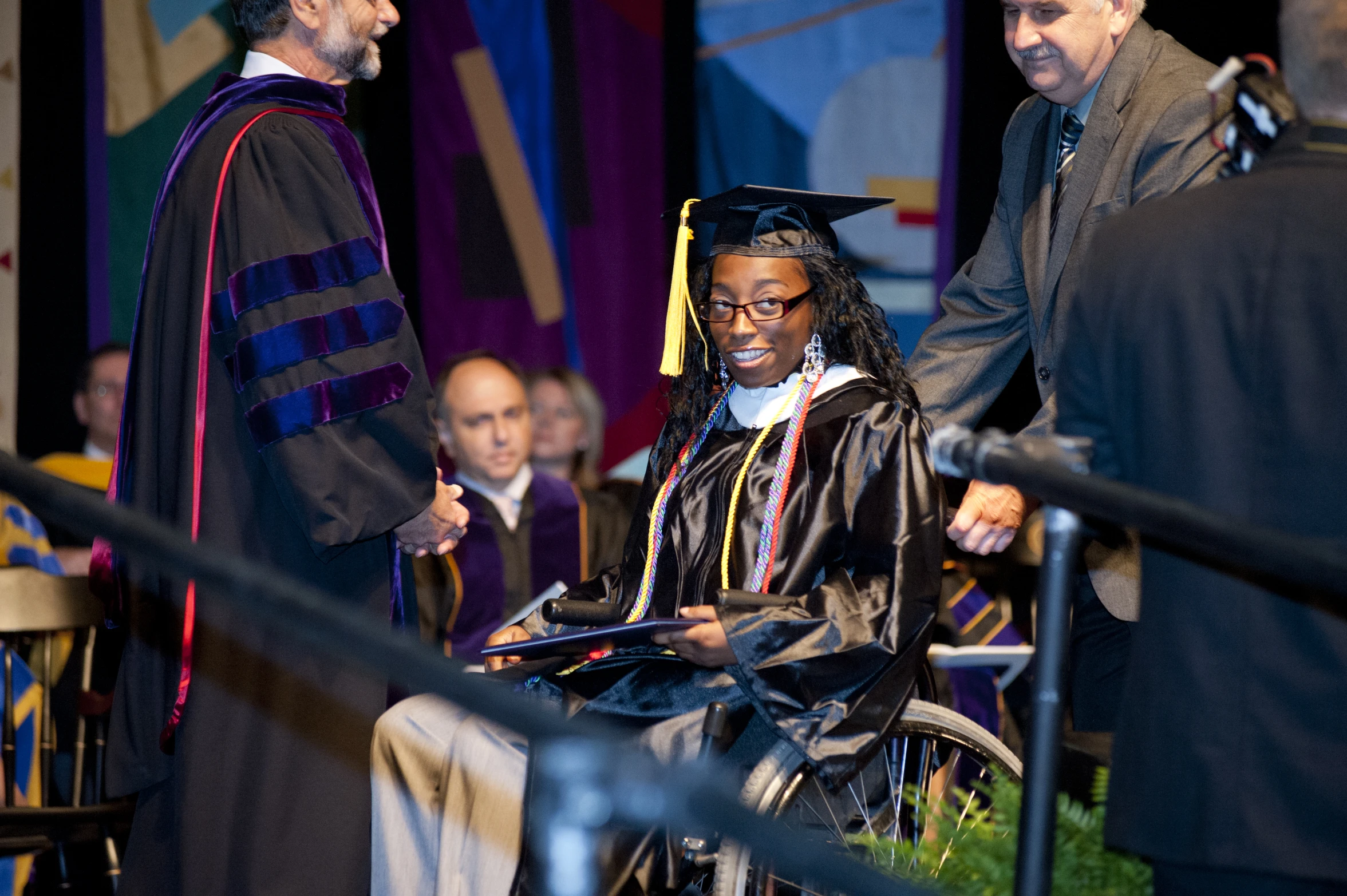 three graduates shaking hands with two other men