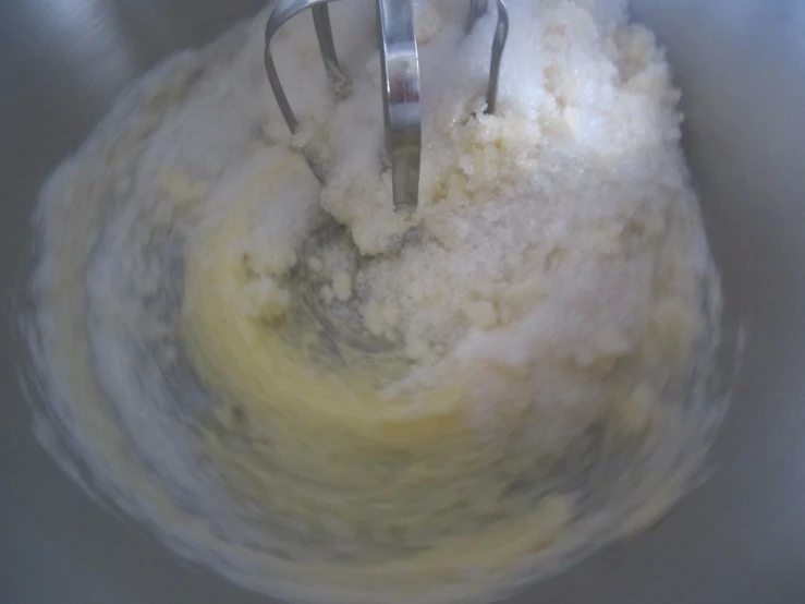 a whisk with sugar is stirred in a bowl