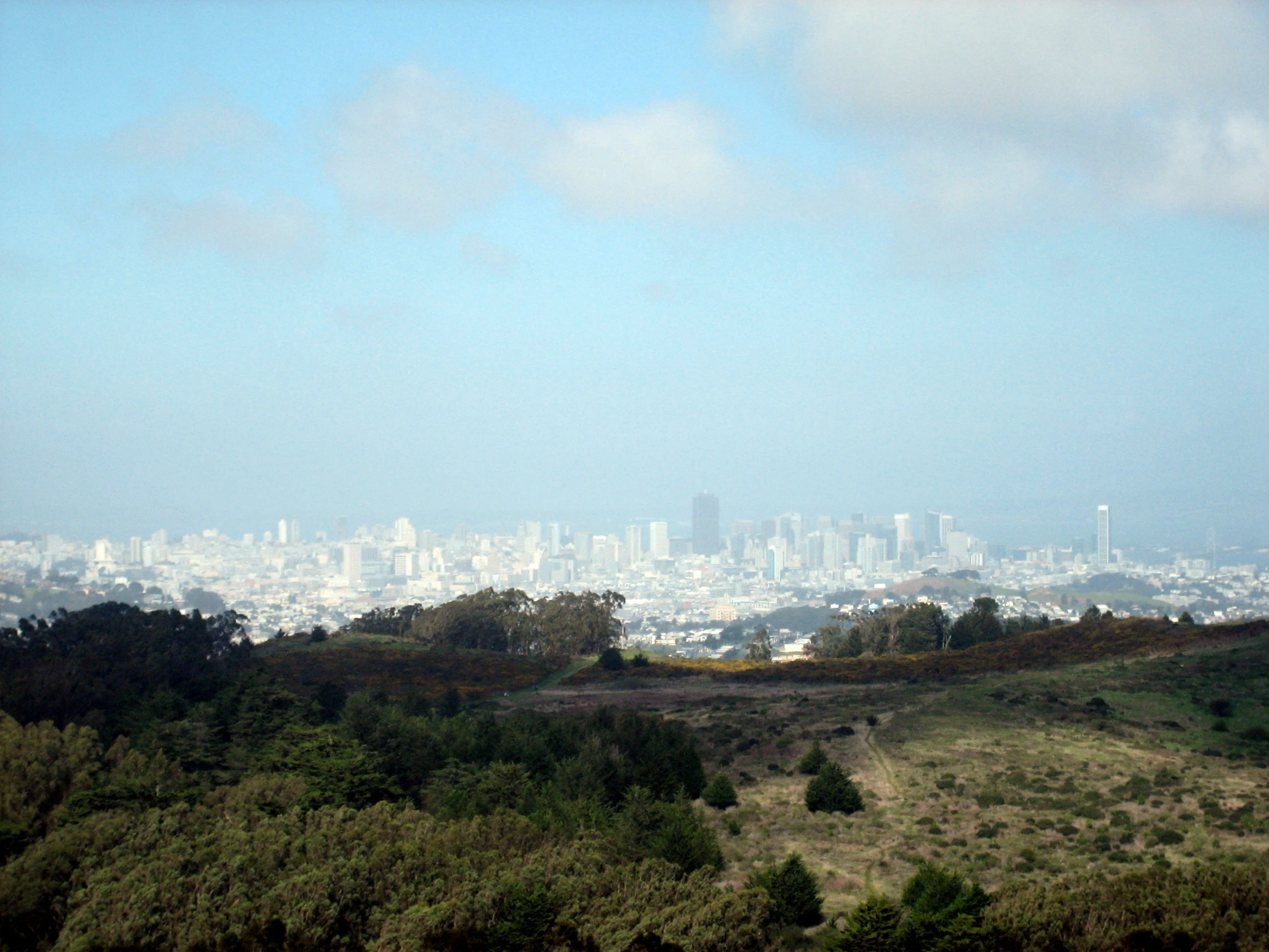 the view of a city and a few hills near a hill