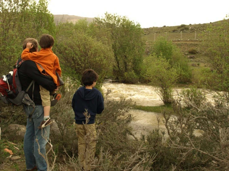 a family watching water in the river during a rainy day