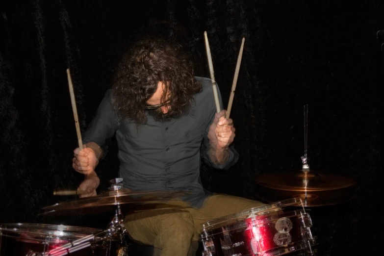 a man playing drums with sticks in his hand
