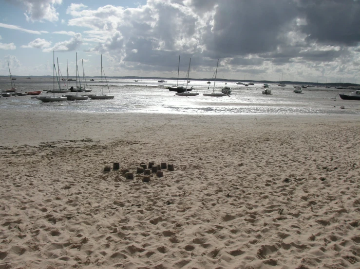 a beach with boats on the water and sand