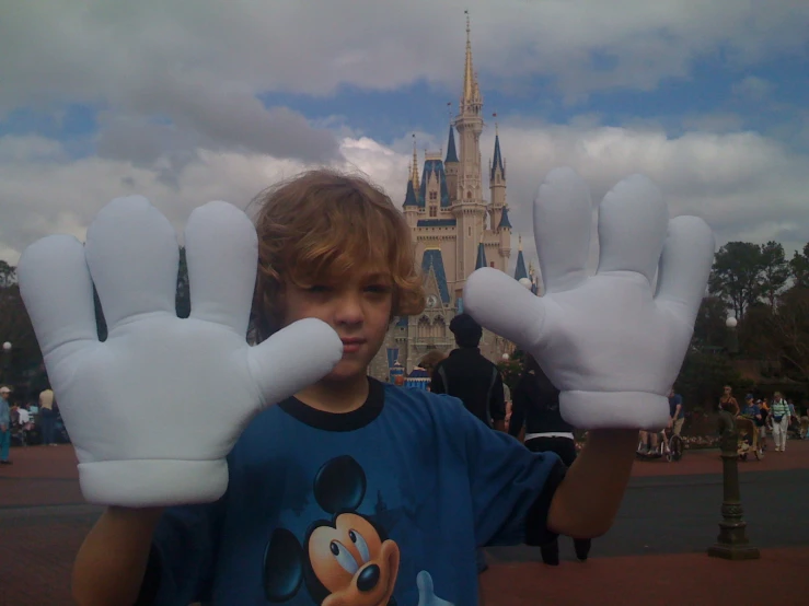the child is showing off his gloves at disney world