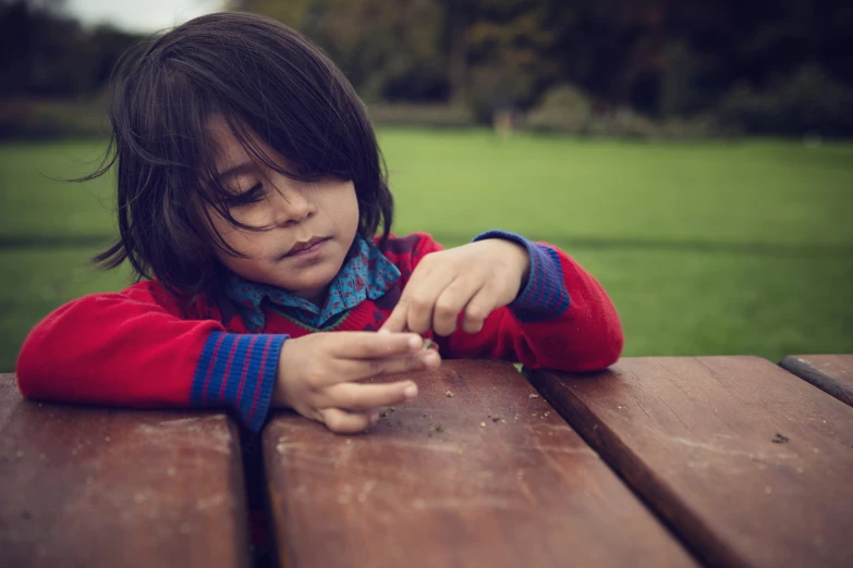 a young child that is sitting down on a wooden table