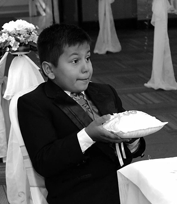 a little boy is standing and holding a cake