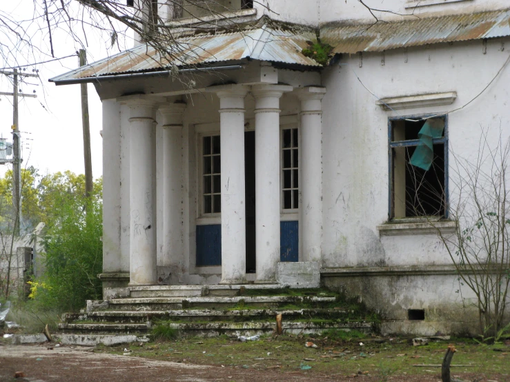 the old building has columns and broken glass in it