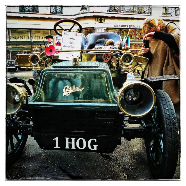 a group of people looking at an old timey car