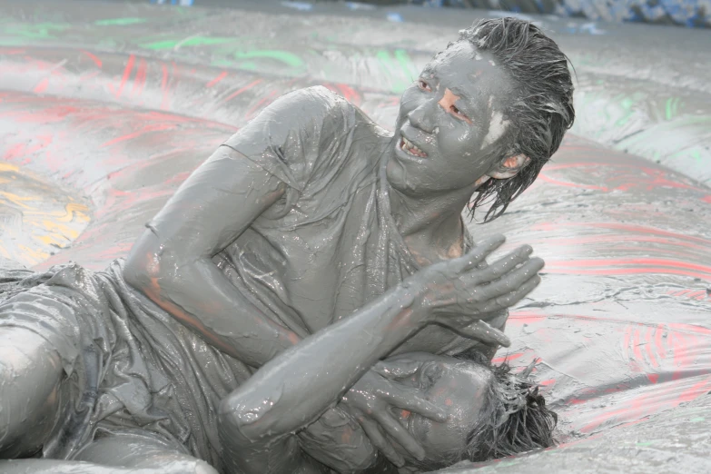 a girl is covered in mud while lying down