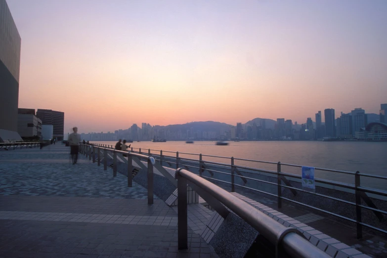 a bench next to the water at sunset