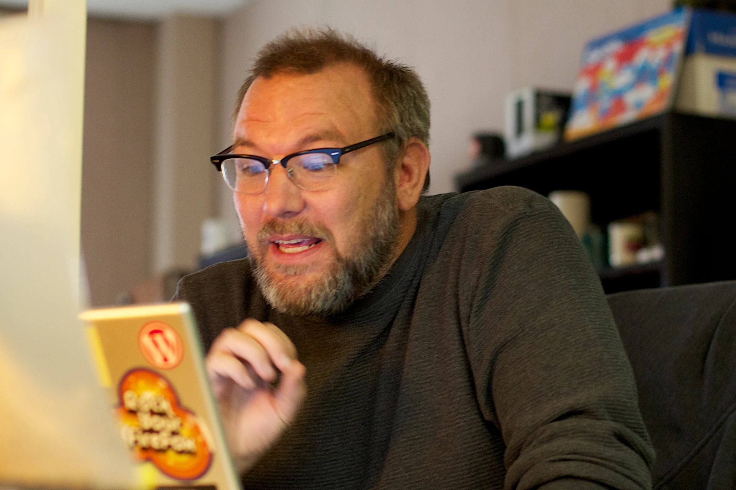 a man wearing glasses looking at a laptop computer screen