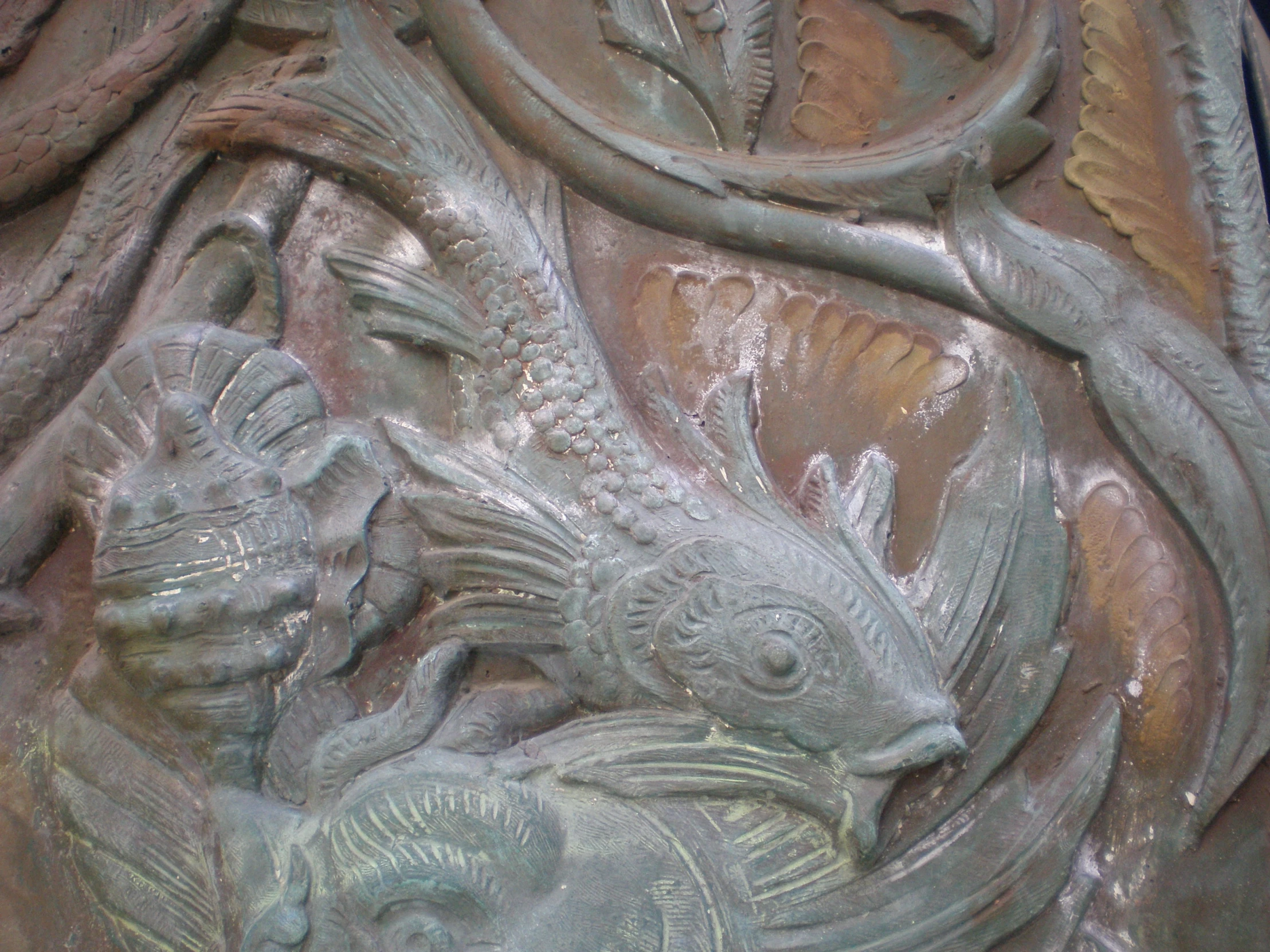 decorative sculpture in center of large piece of metal