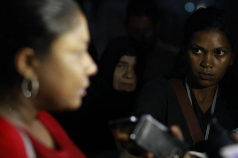 women in crowd looking at each other as they discuss soing