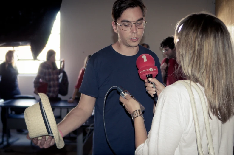 a man with a microphone talking to a reporter