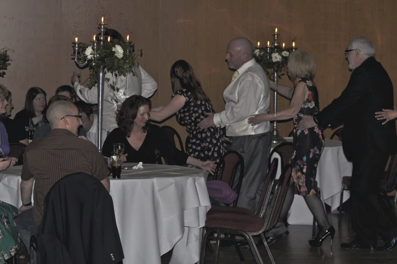 a bunch of people are dancing around a small table