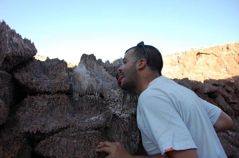 the man has his face close to a rock