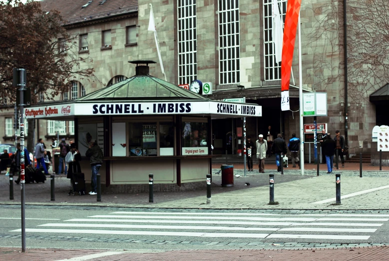 people walk by the storefront of an old building