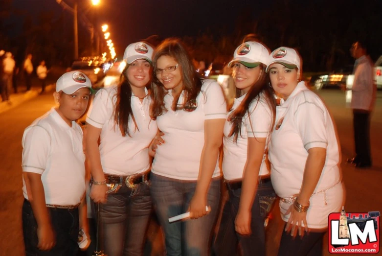 a group of girls wearing matching white shirts and hats