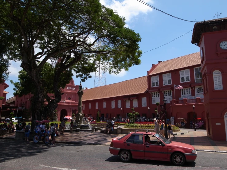 a small red car parked in front of a building