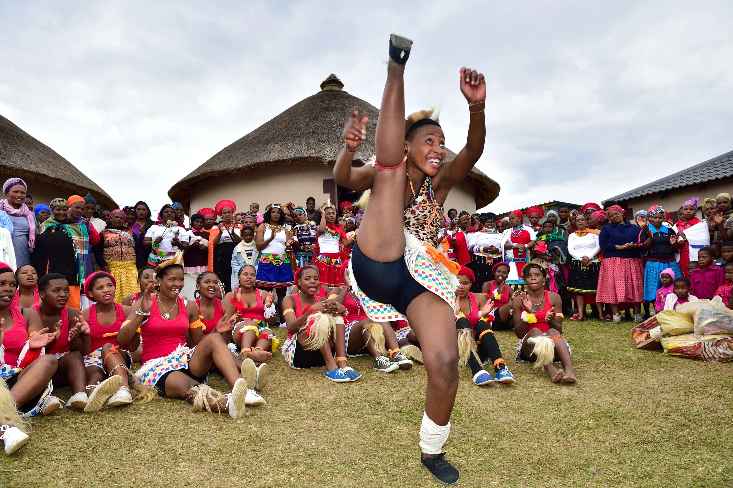 a woman in a cheerleader costume standing on a lush green field