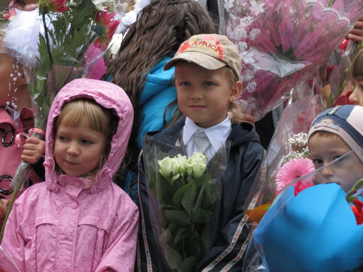 the little boys are holding flowers outside