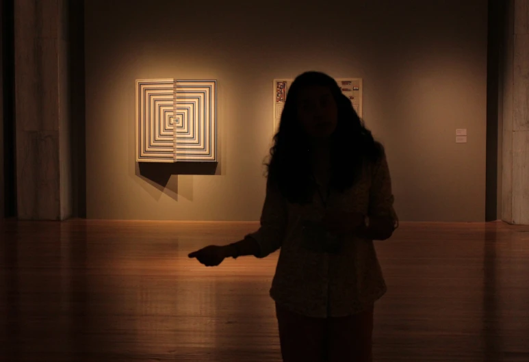 a girl is in the hallway of a museum holding her hands out