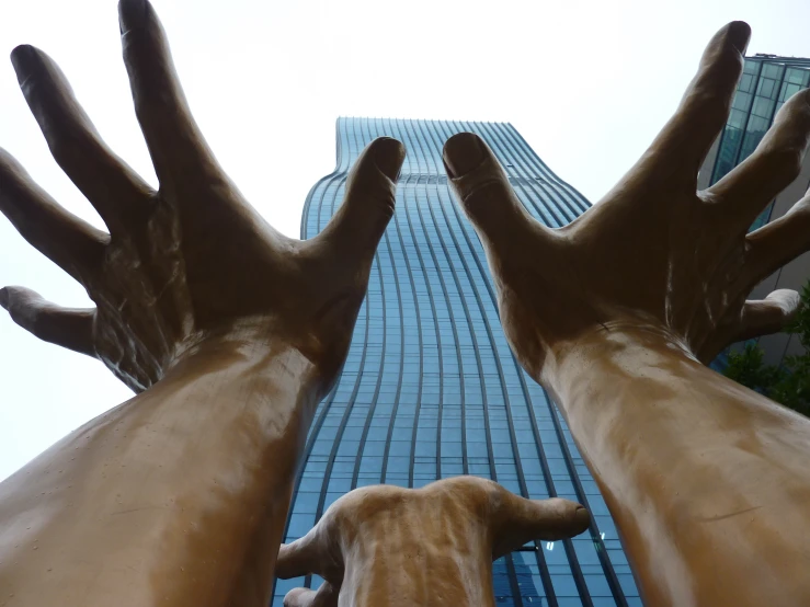 a large bronze sculpture is in front of a very tall building