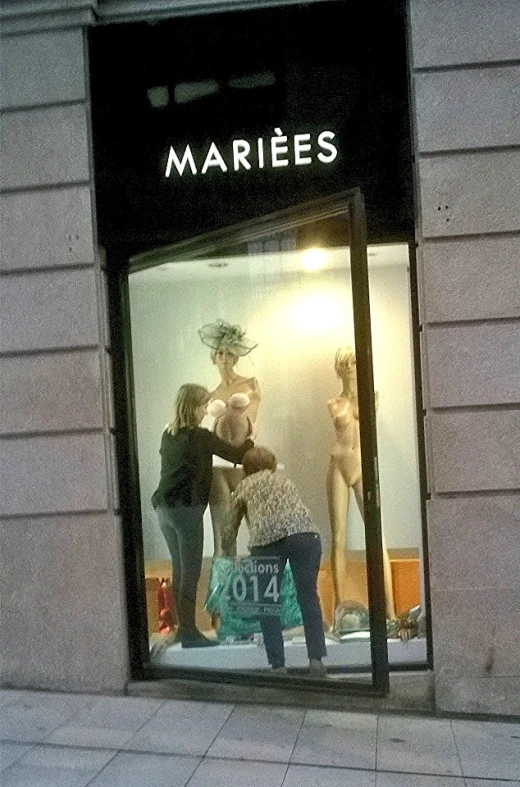a store front window with mannequins dressed in clothes