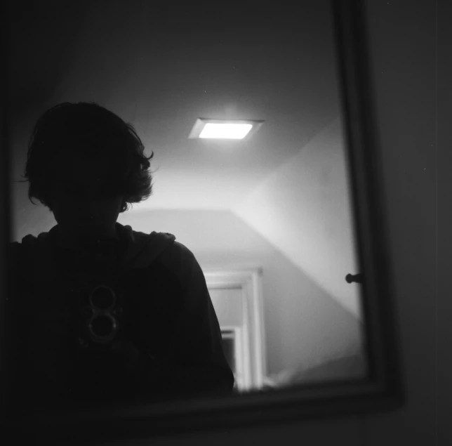 black and white pograph of woman taking po in mirror