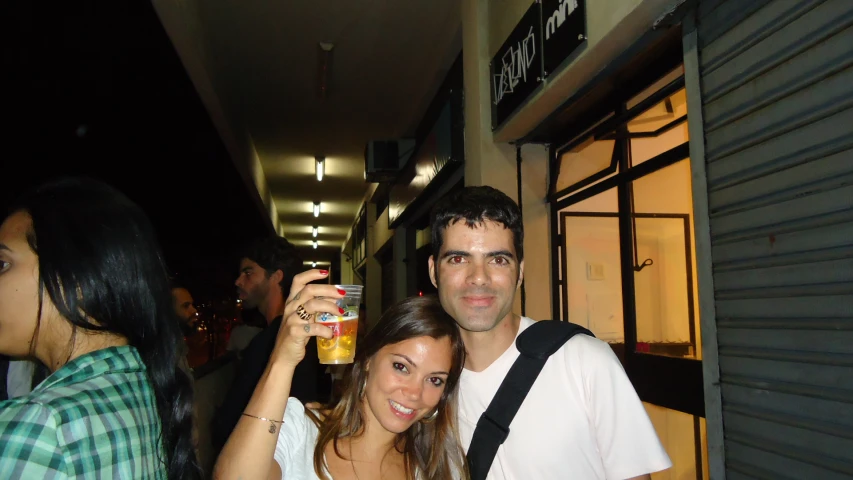 a group of people standing on a sidewalk next to one another