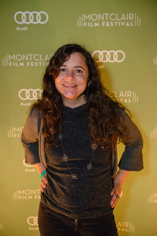 a woman with long brown hair standing on a red carpet