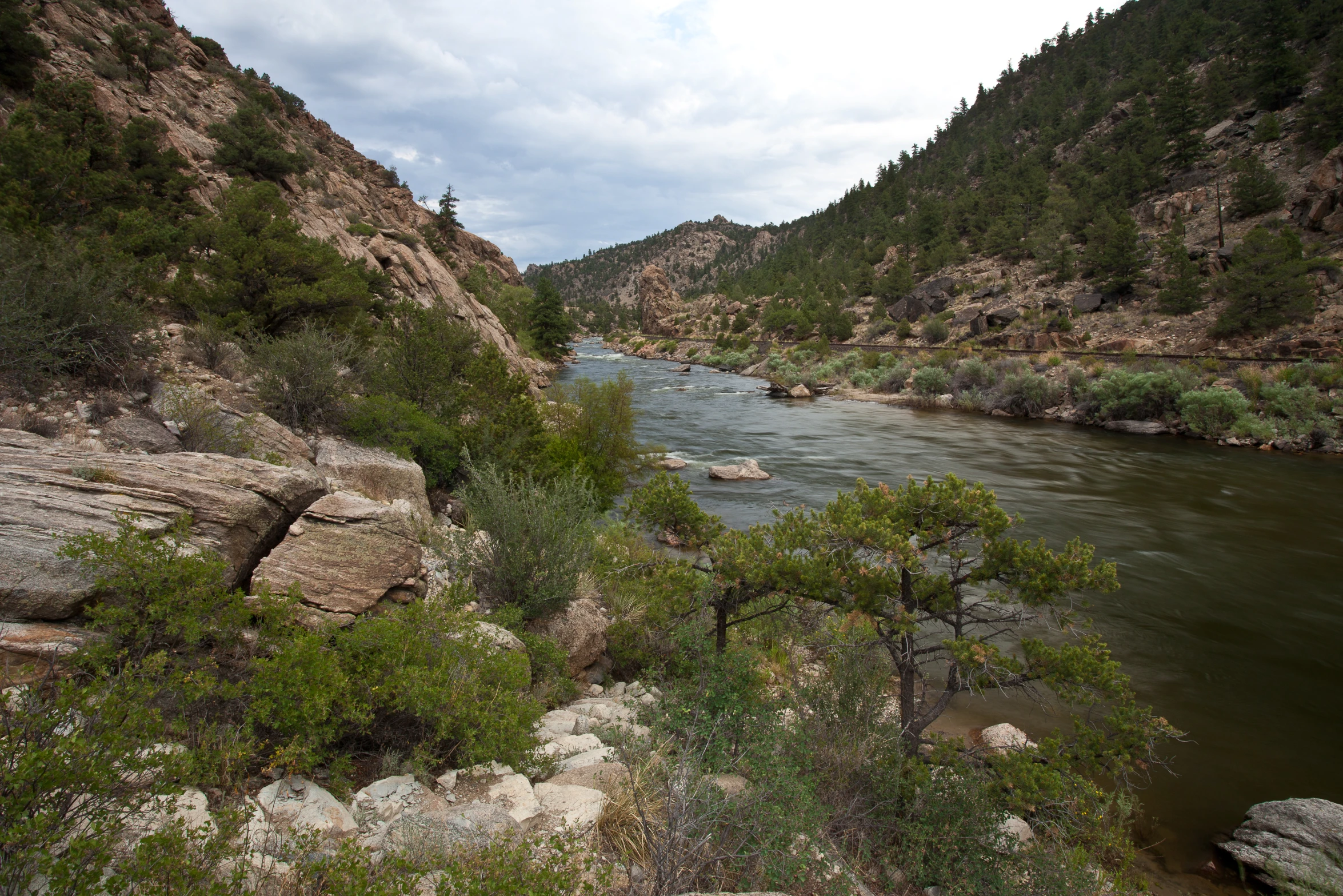 a river running through a canyon near rocky mountains